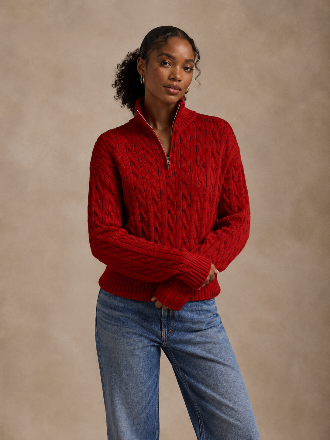 Model wearing a red cable-knit quarter zip with relaxed denim
